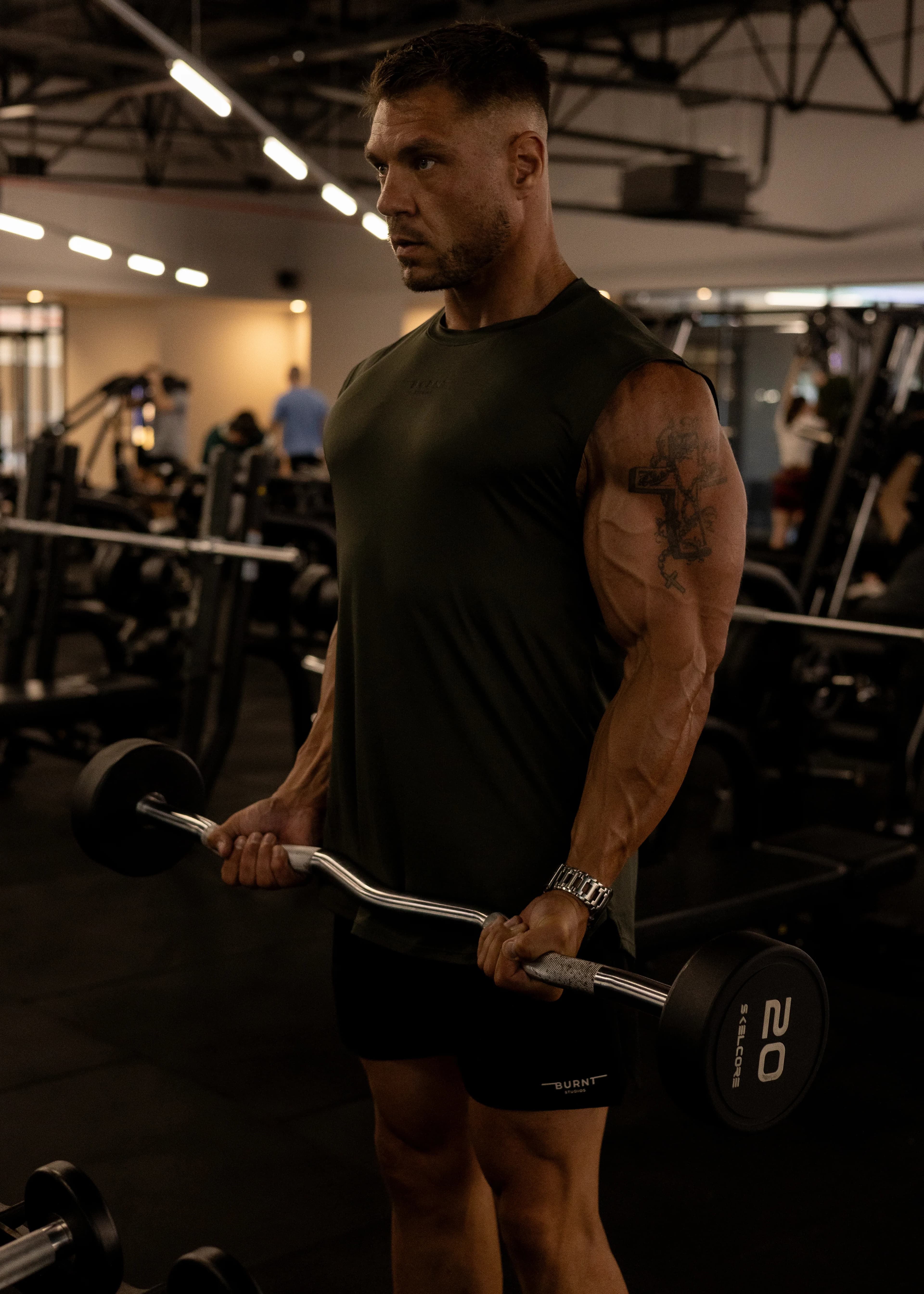 Hugo Arangies, The 146 Method coach, barbell curl in a dark commercial gym